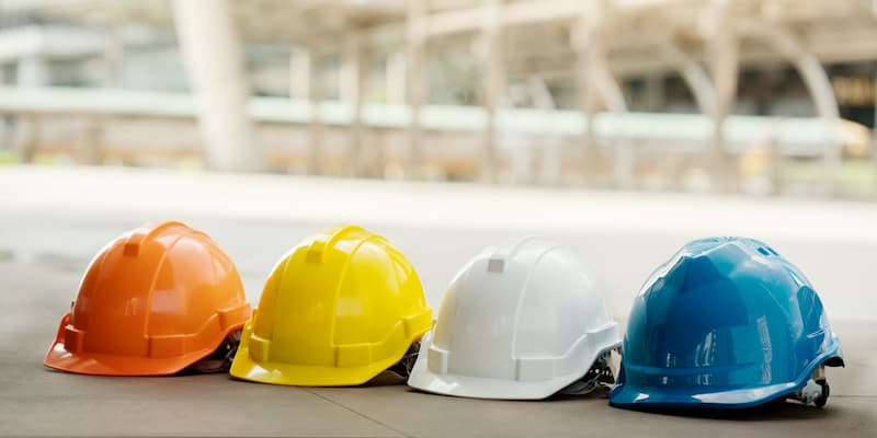 hard hats in colours orange yellow white blue